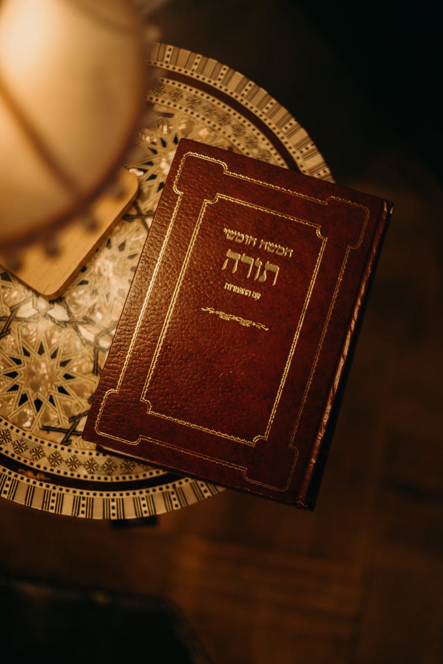 book in hebrew next to a lamp