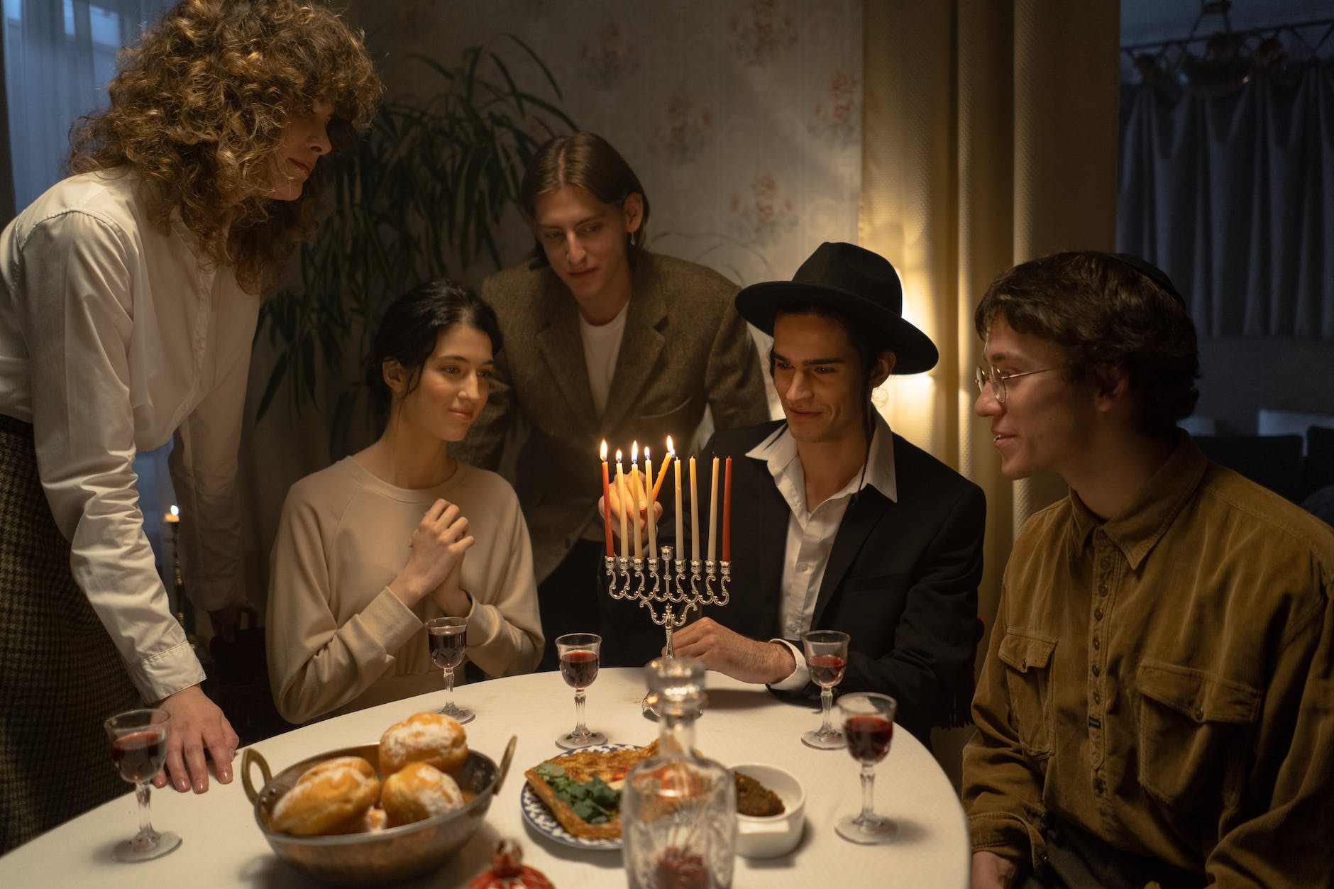 man lighting up candles in menorah